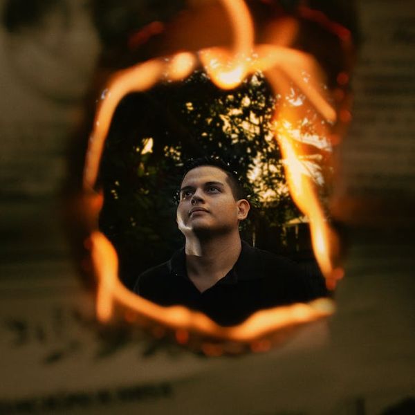 Silhouette of a man in a powerful stance against a vibrant background.